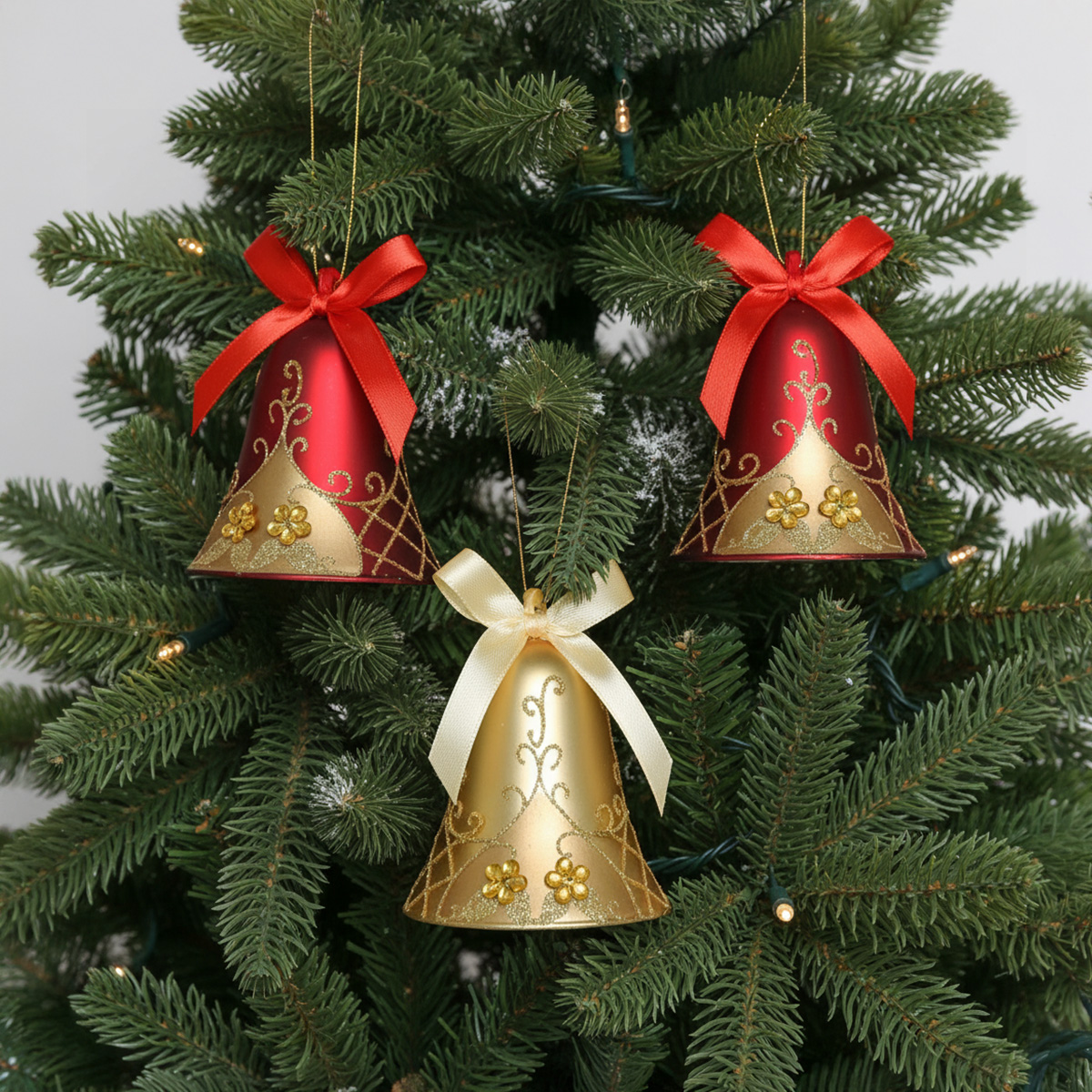 Campanelle di Natale rosse e dorate appese all'albero di Natale