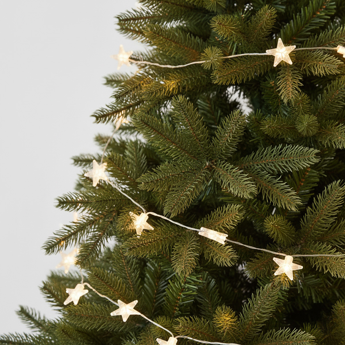 Guirlande lumineuse en forme d'étoiles sur un sapin de Noël