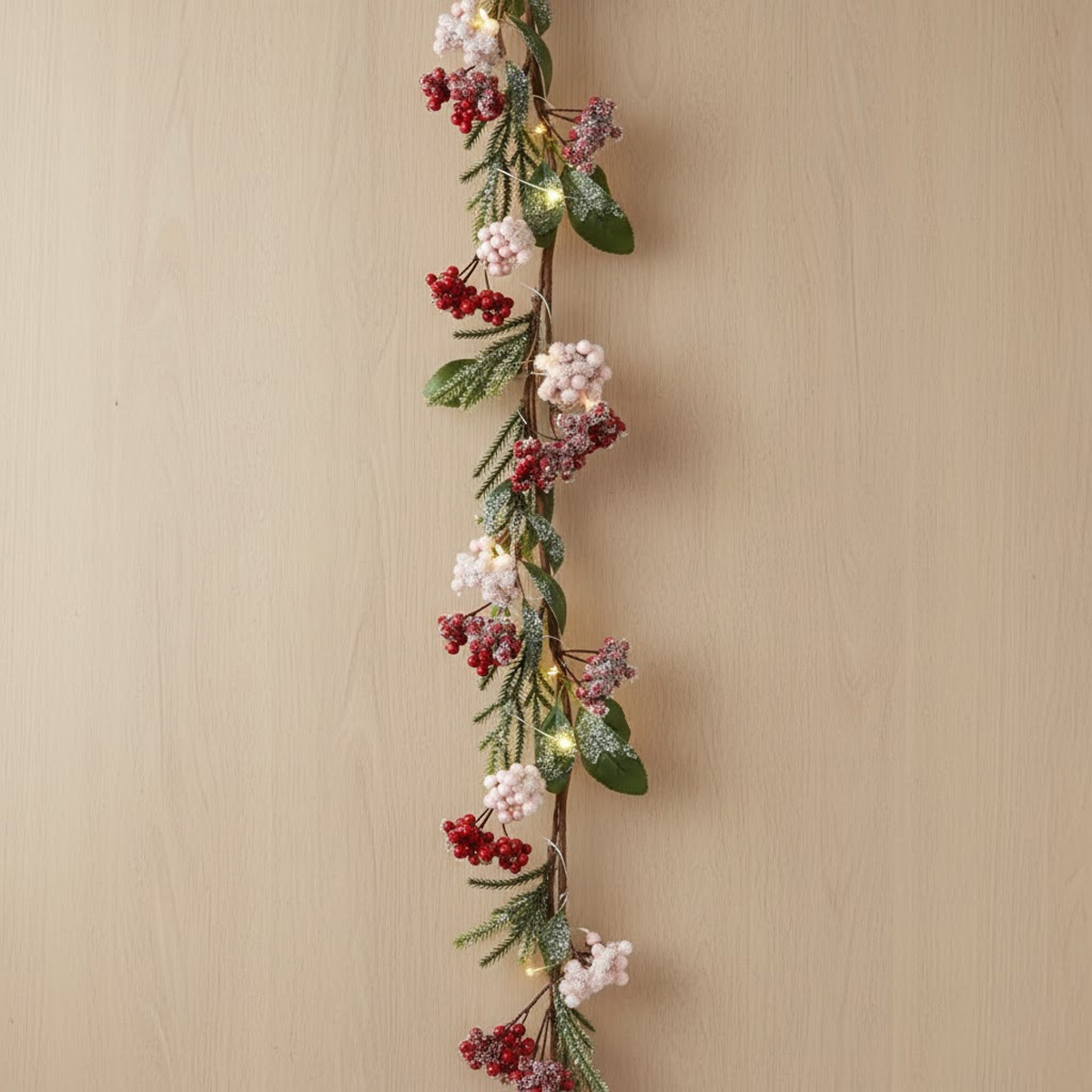 Christmas string lights with red and white berries and frosted fir branches