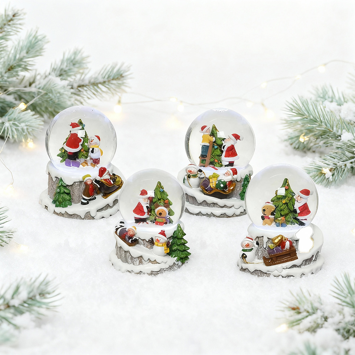 Quatre boules à neige de Noël avec des scènes de Père Noël et des bonhommes de neige