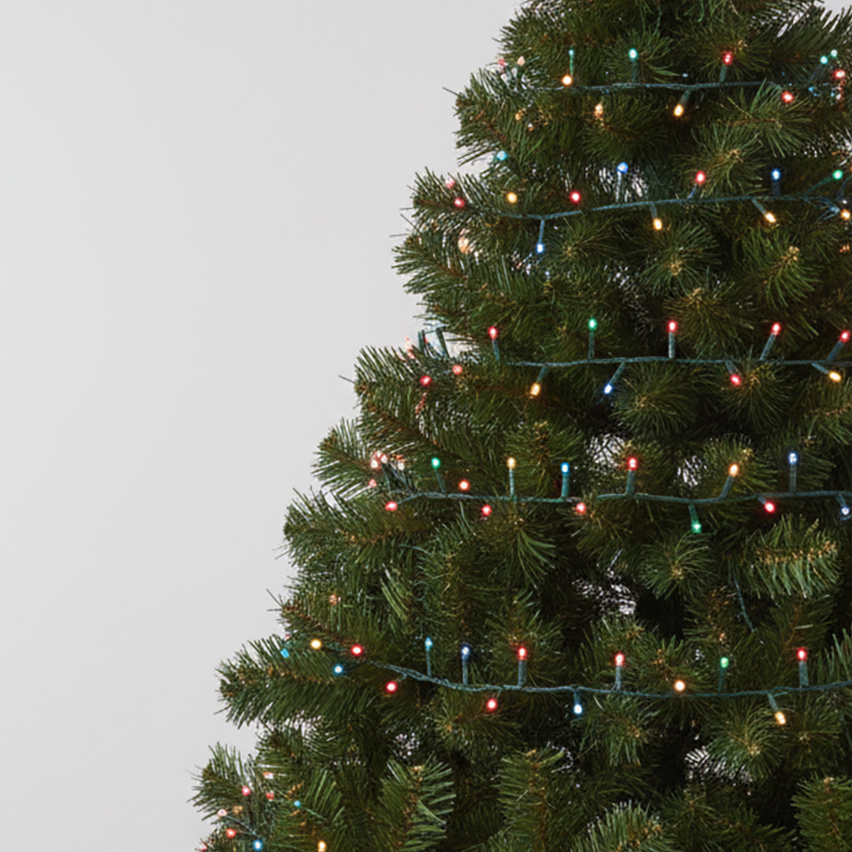 Gros plan sur un sapin de Noël décoré de guirlandes lumineuses colorées