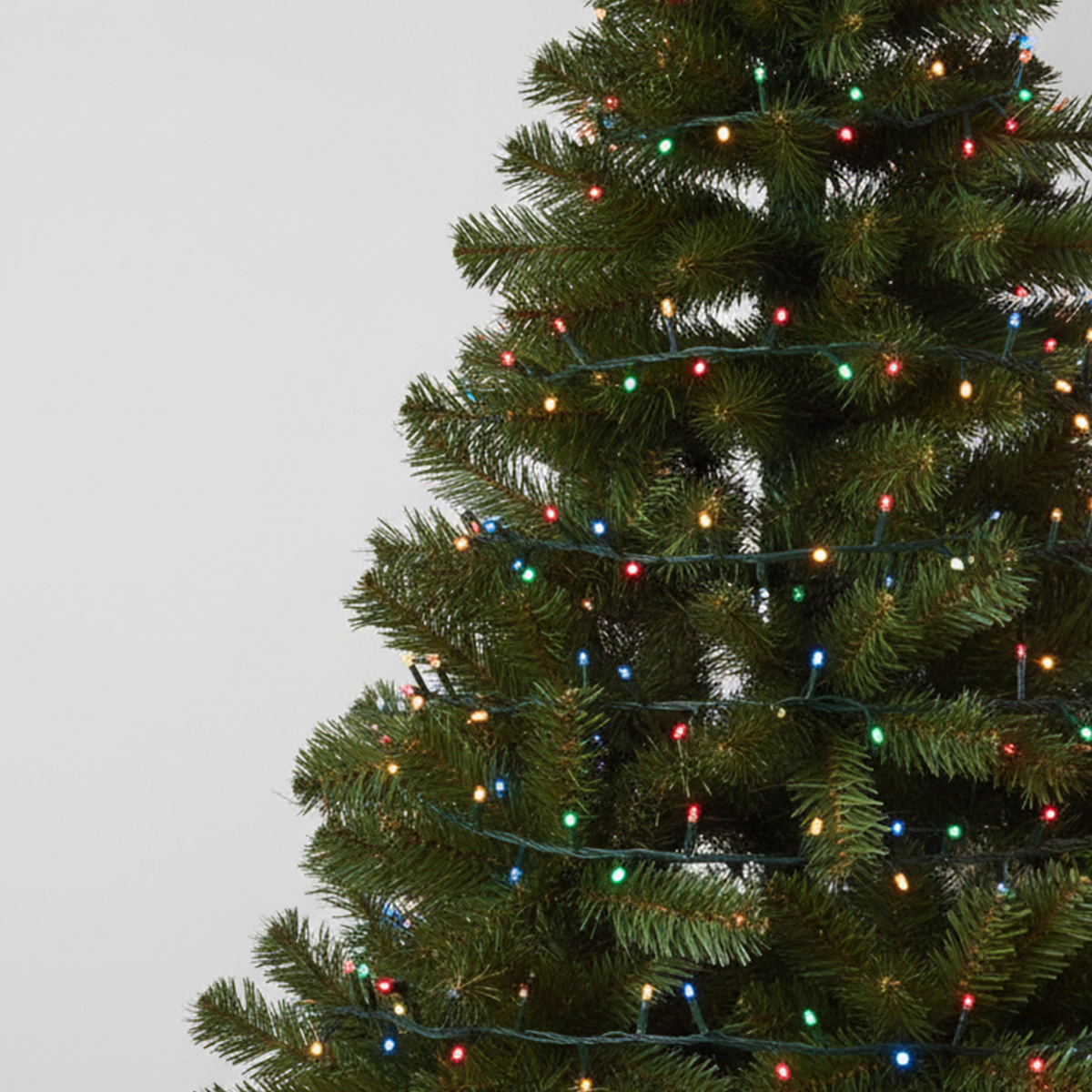 Gros plan sur un sapin de Noël décoré de guirlandes lumineuses multicolores