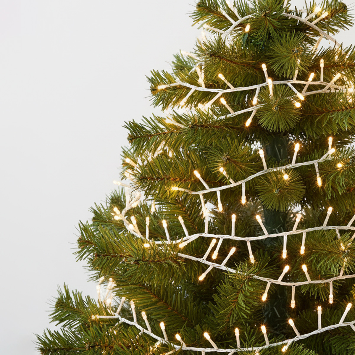 Luces de cadena blancas en un árbol de Navidad verde