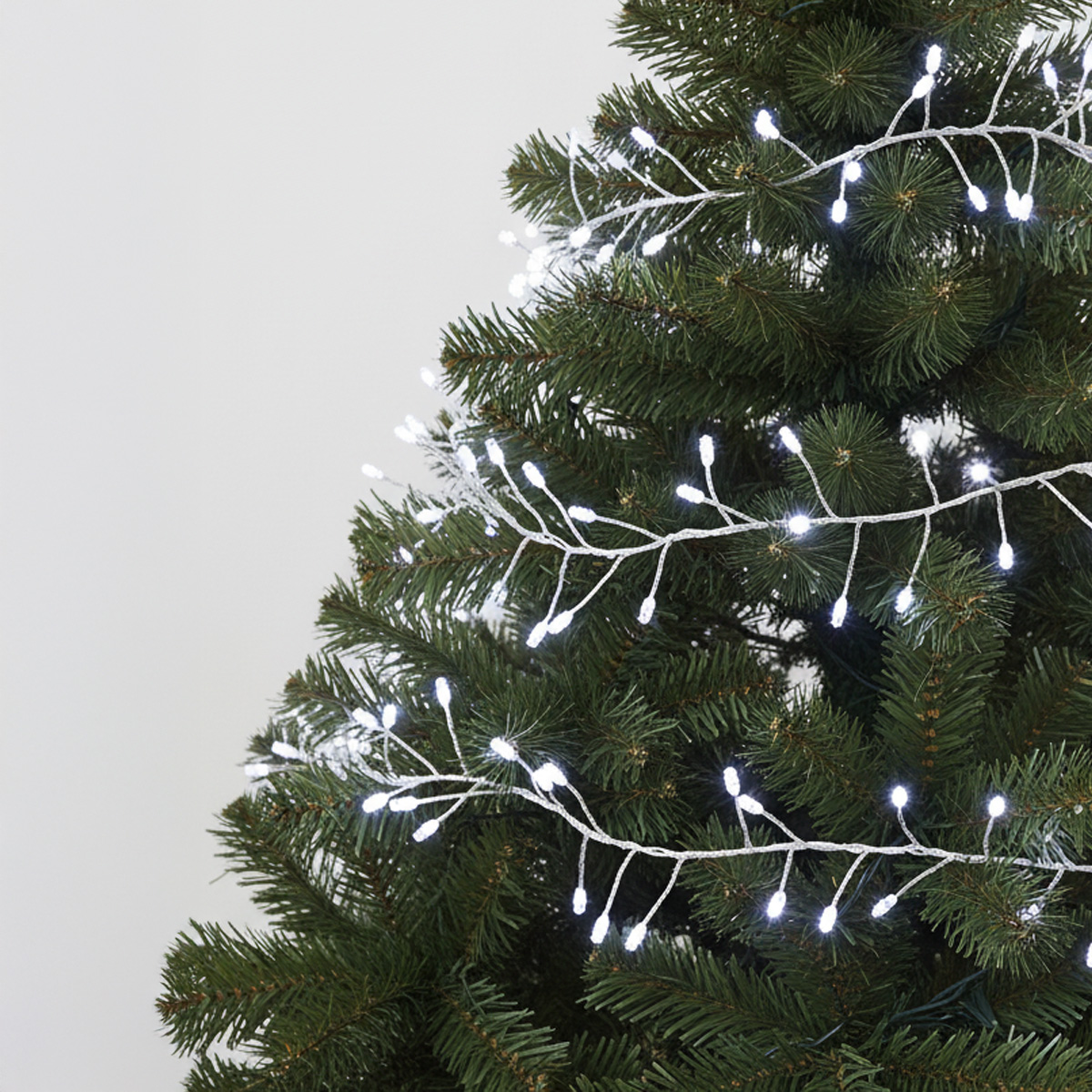 Witte lichtslingers in een groene kerstboom