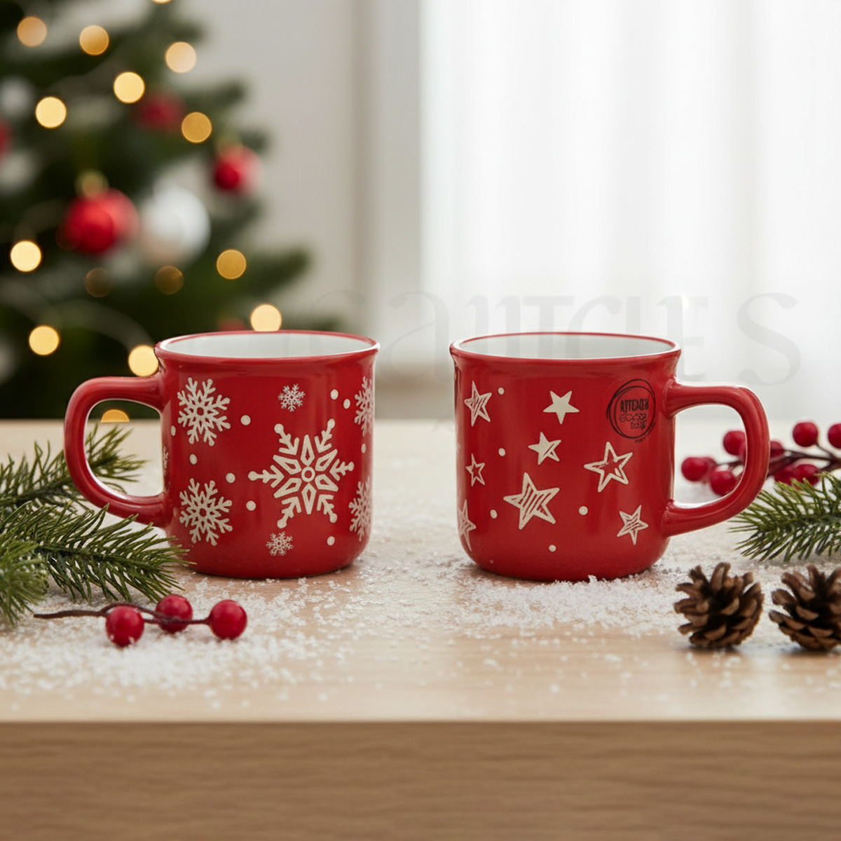 Twee rode kerstmokken, één met sneeuwvlokken, de andere met sterren