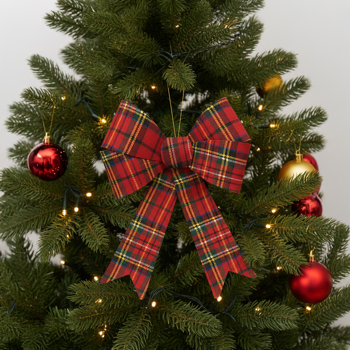 Nœud écossais rouge sur un sapin de Noël décoré
