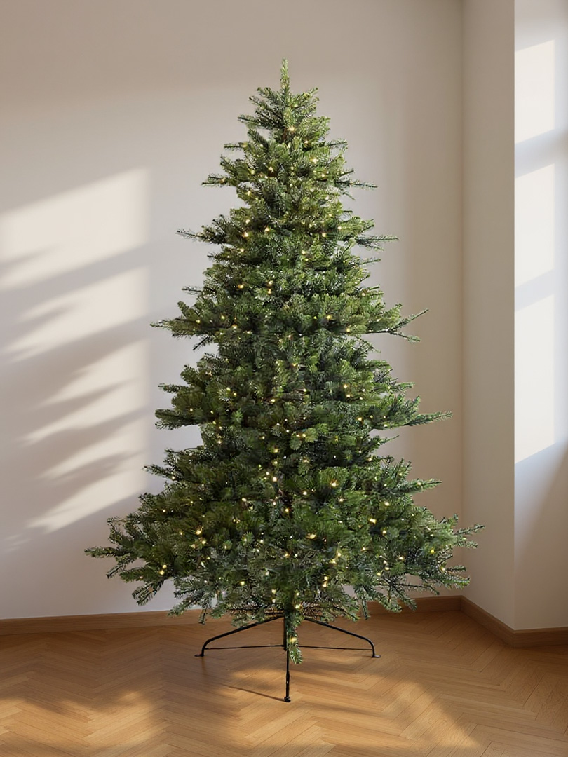 Large pre-lit artificial green Christmas tree with small warm lights