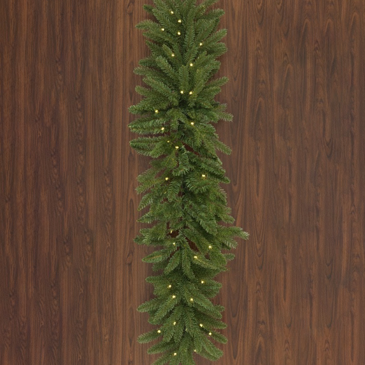 Green fir garland with lights on a wooden background