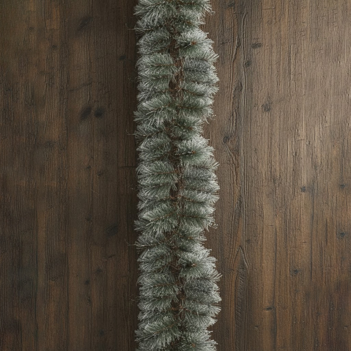 Frosted fir garland on a dark wood background