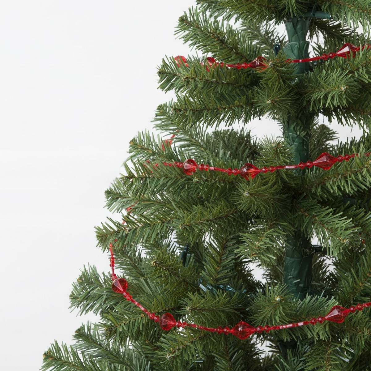 Sapin de Noël vert avec guirlande de perles rouges