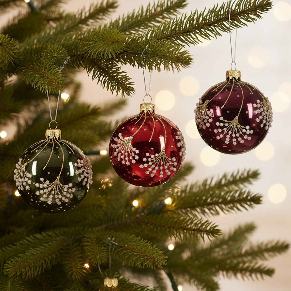 Boules de Noël vertes et rouges décorées de flocons de neige scintillants