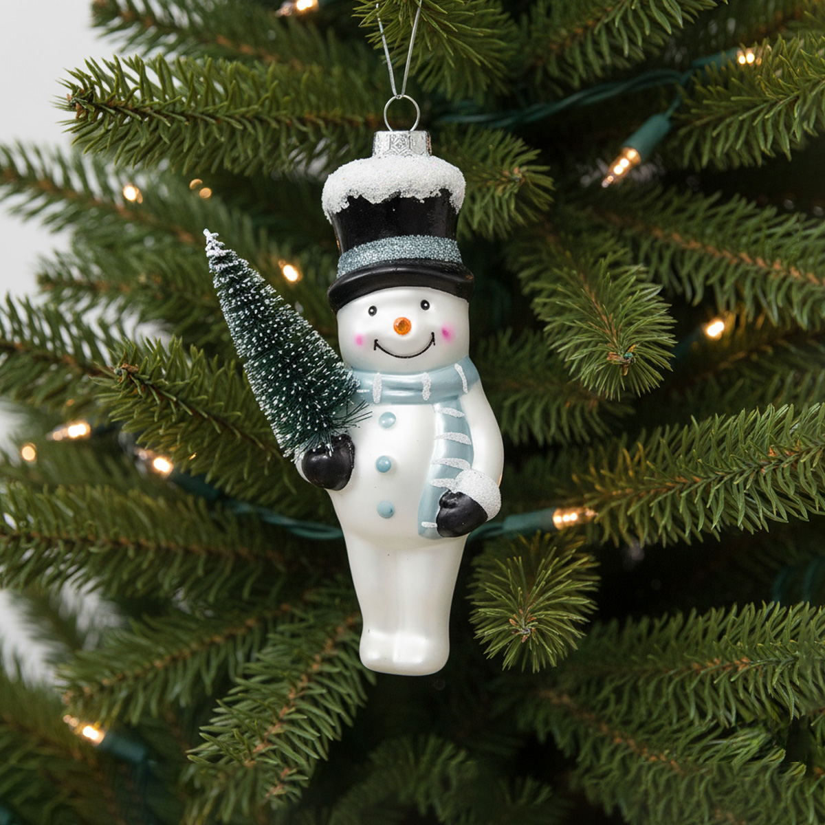 Ornement de bonhomme de neige tenant un petit sapin de Noël
