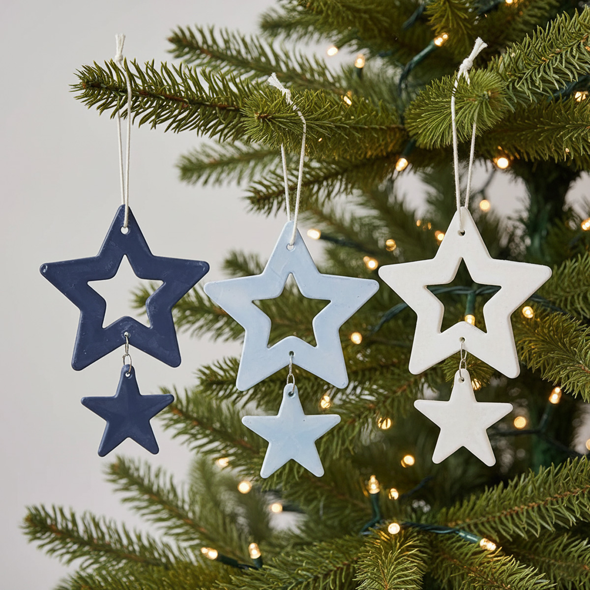 Décorations d'étoiles de Noël bleues, claires et blanches suspendues à un sapin