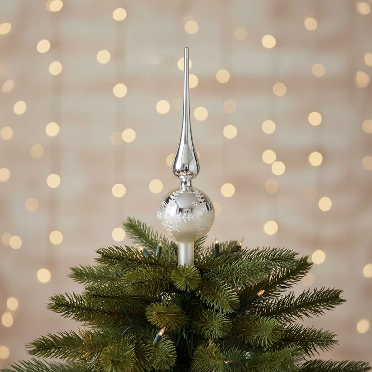 Pointe d'arbre de Noël argentée ornée de flocons de neige
