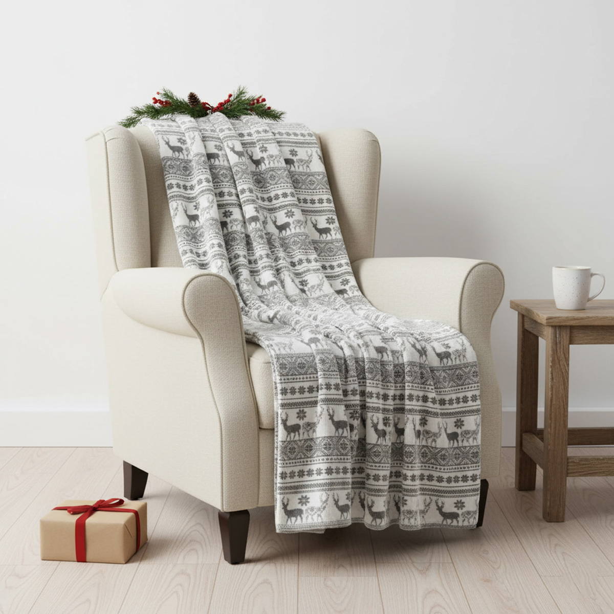 Couverture à motifs de cerfs sur un fauteuil beige avec un cadeau et une tasse