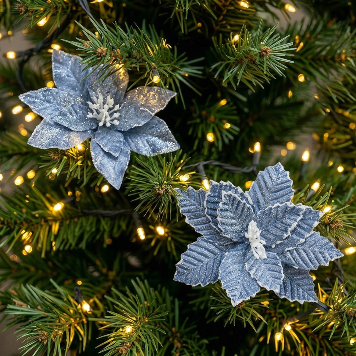 Fleurs de poinsettia bleues scintillantes sur un sapin de Noël avec des lumières