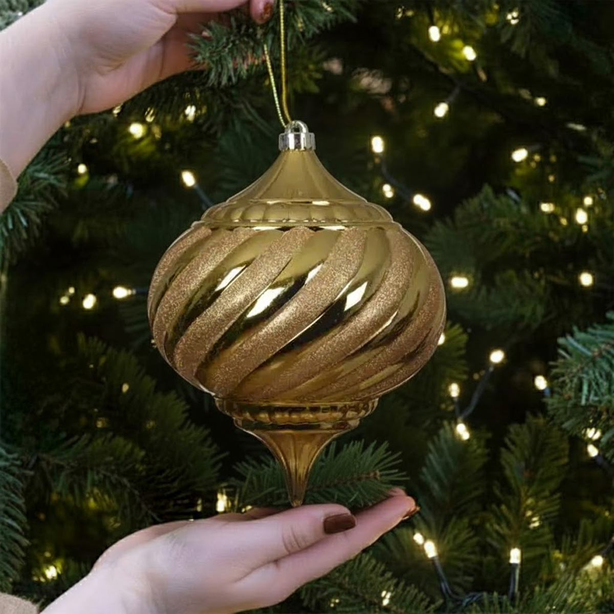 Pallina di Natale dorata intrecciata su un albero decorato