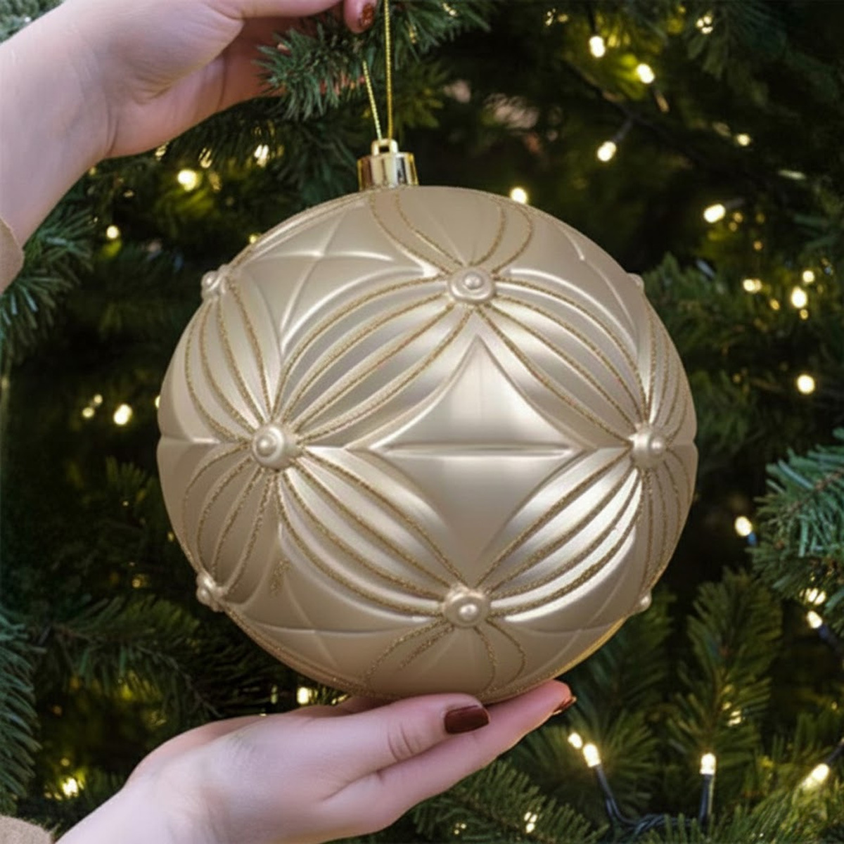Boule de Noël dorée avec motif géométrique sur un sapin décoré