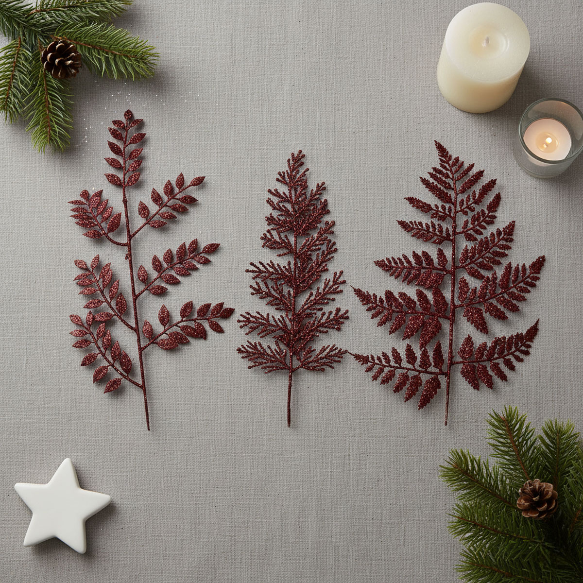 Branches de fougères artificielles rouges pailletées avec des bougies et des branches de sapin