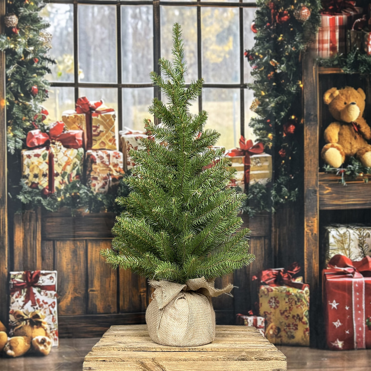 Petit sapin de Noël décoré pour les fêtes, sur une table en bois.