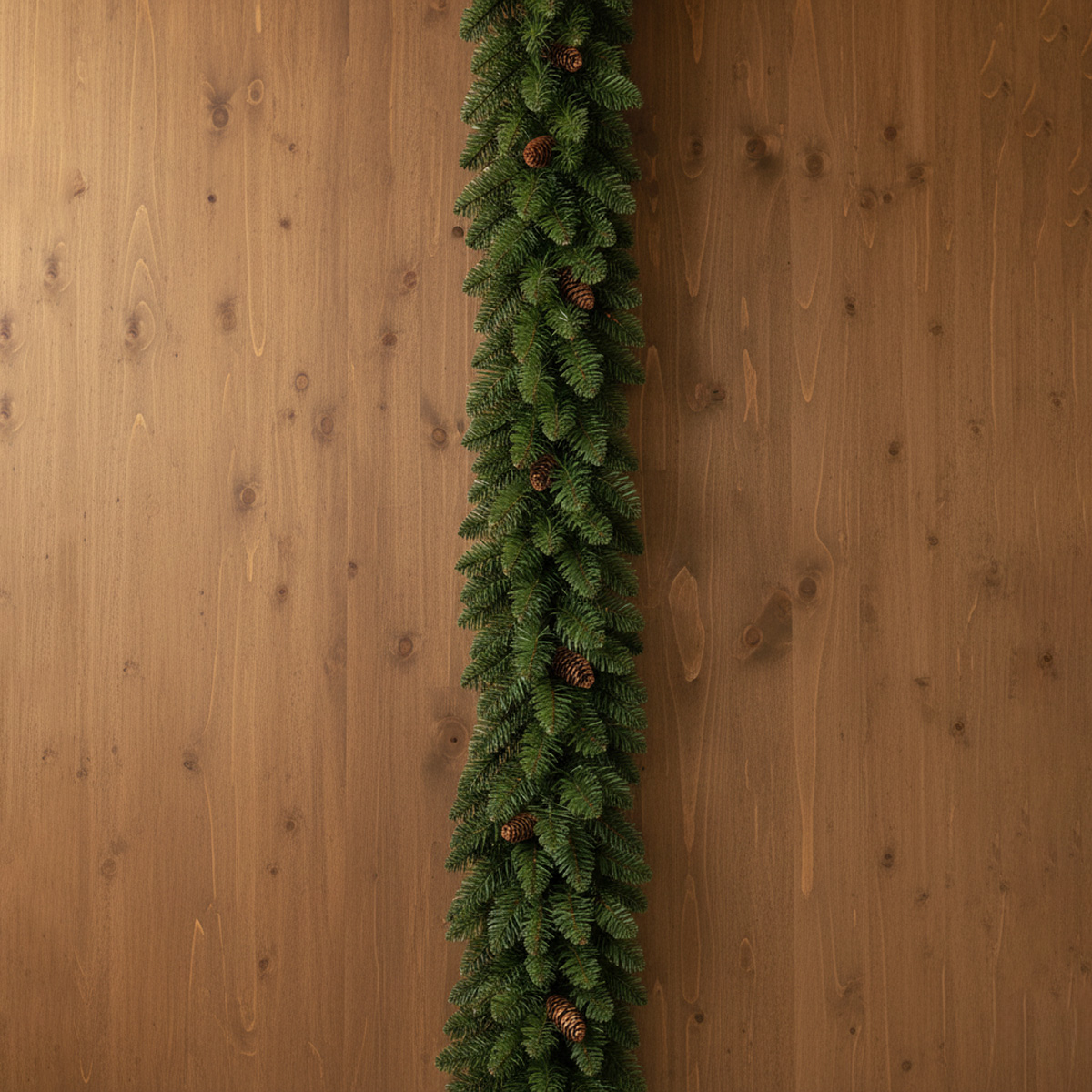 Guirlande de sapin vert avec pommes de pin sur fond de bois