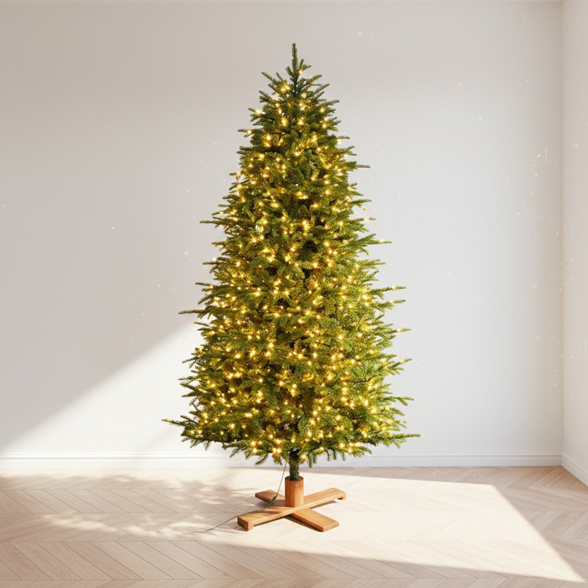 Green Christmas tree illuminated with yellow lights on a wooden floor