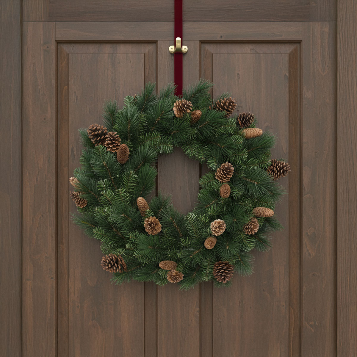 Couronne de sapin avec pommes de pin sur une porte en bois marron