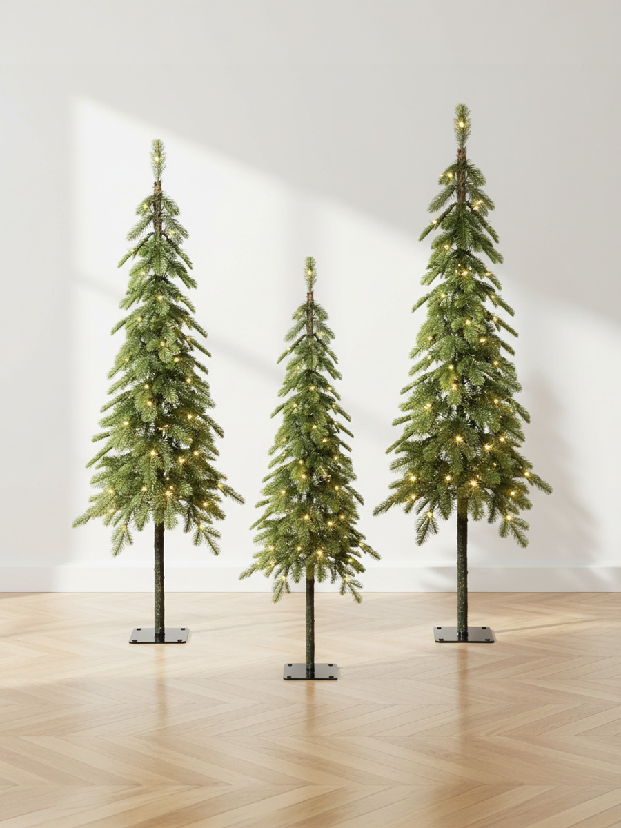 Trois sapins de Noël artificiels illuminés sur un parquet