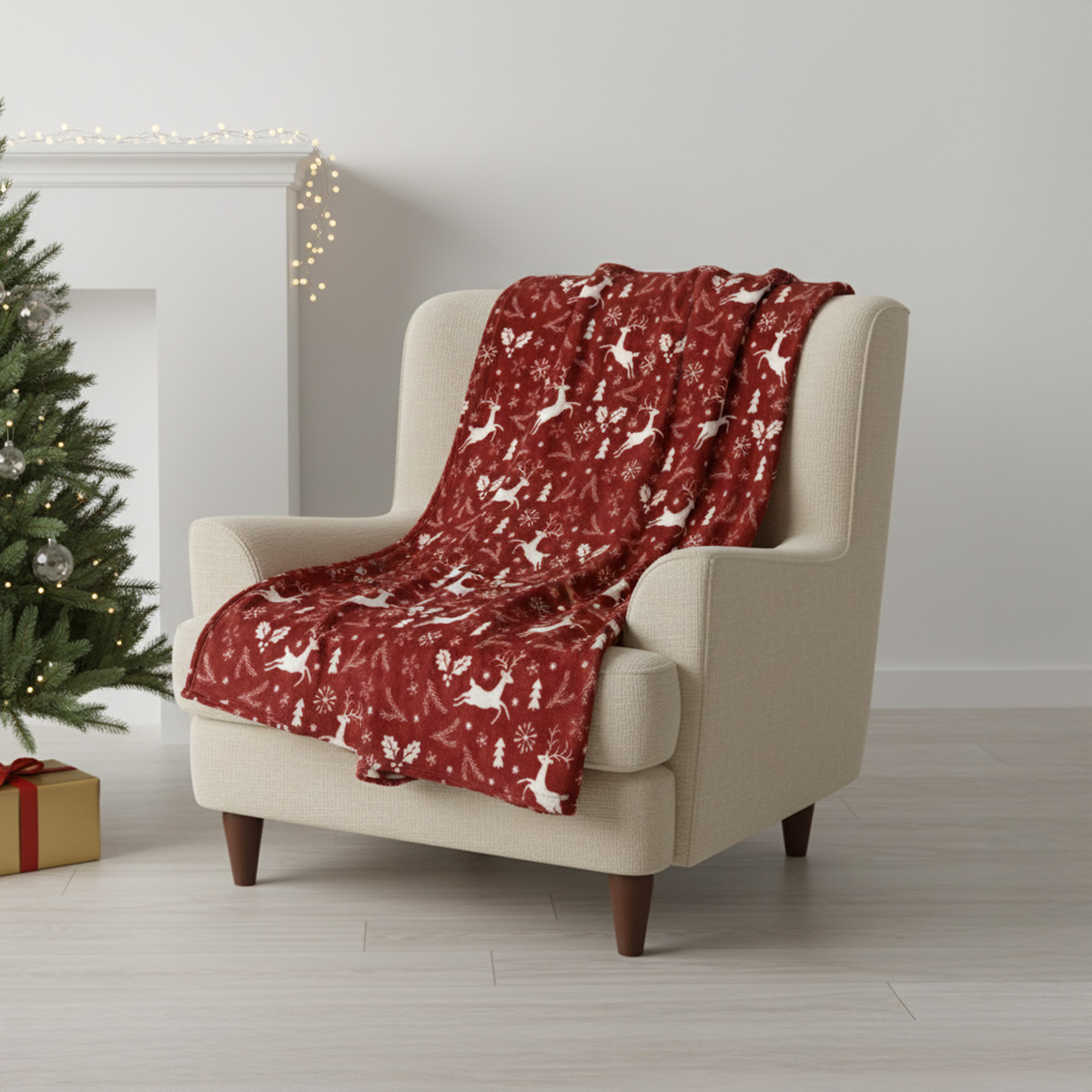 Couverture rouge avec des rennes et des flocons de neige sur un fauteuil beige