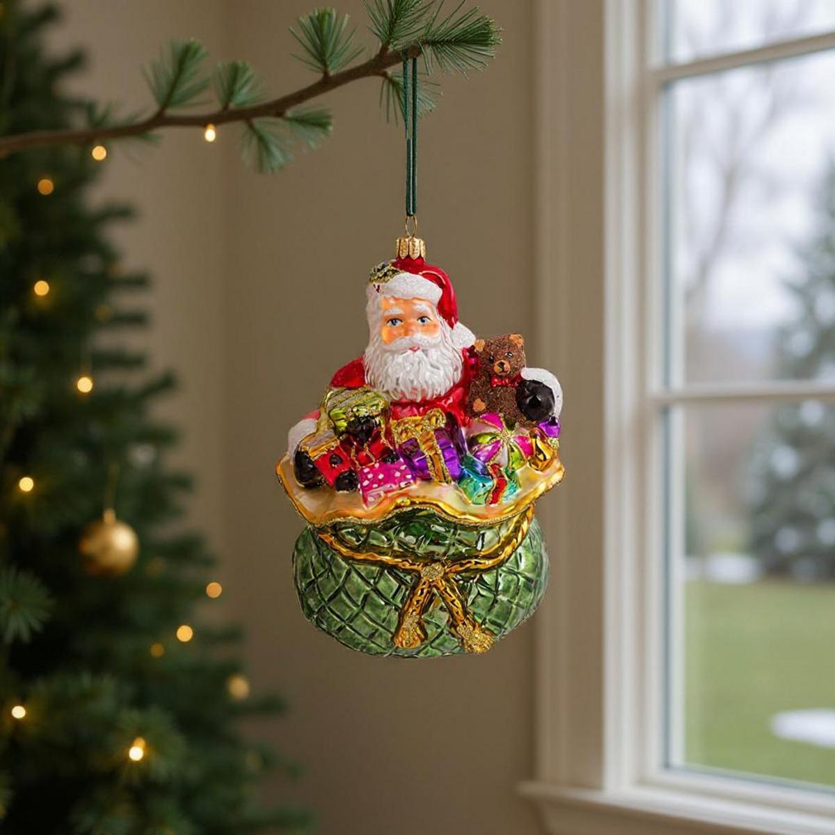 Ornamento di Babbo Natale in una borsa piena di regali e un orsacchiotto