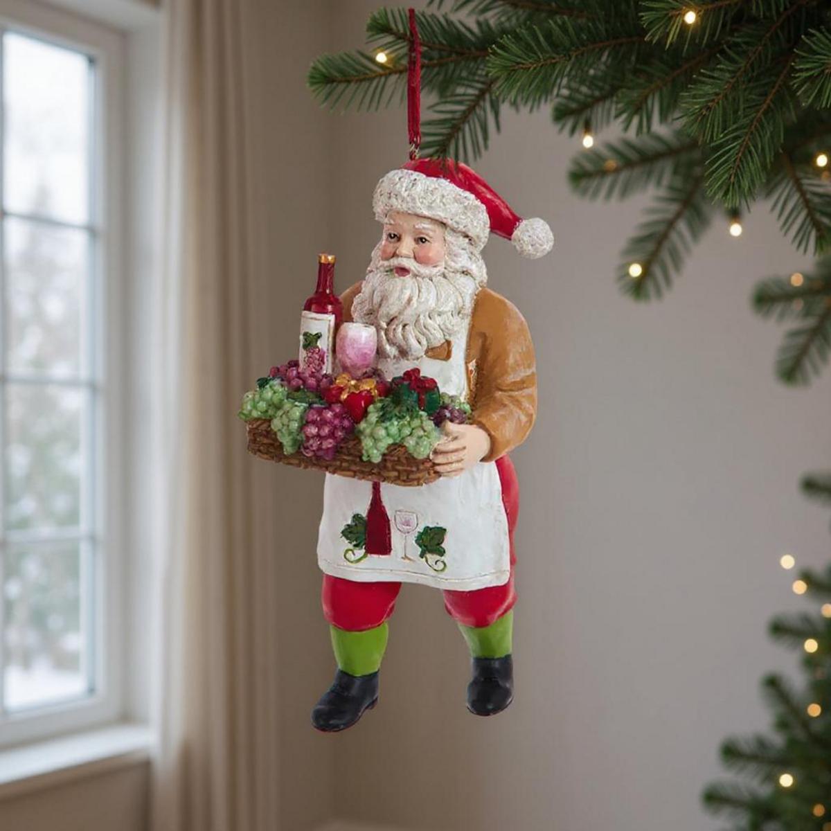 Père Noël avec un panier de fruits et de vin suspendu à un sapin