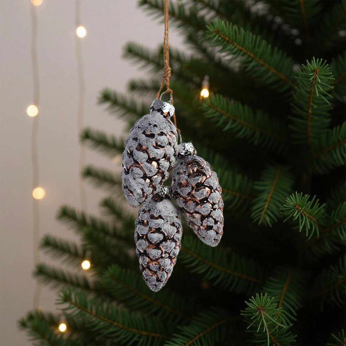 Tre pigne decorative appese a un albero di Natale