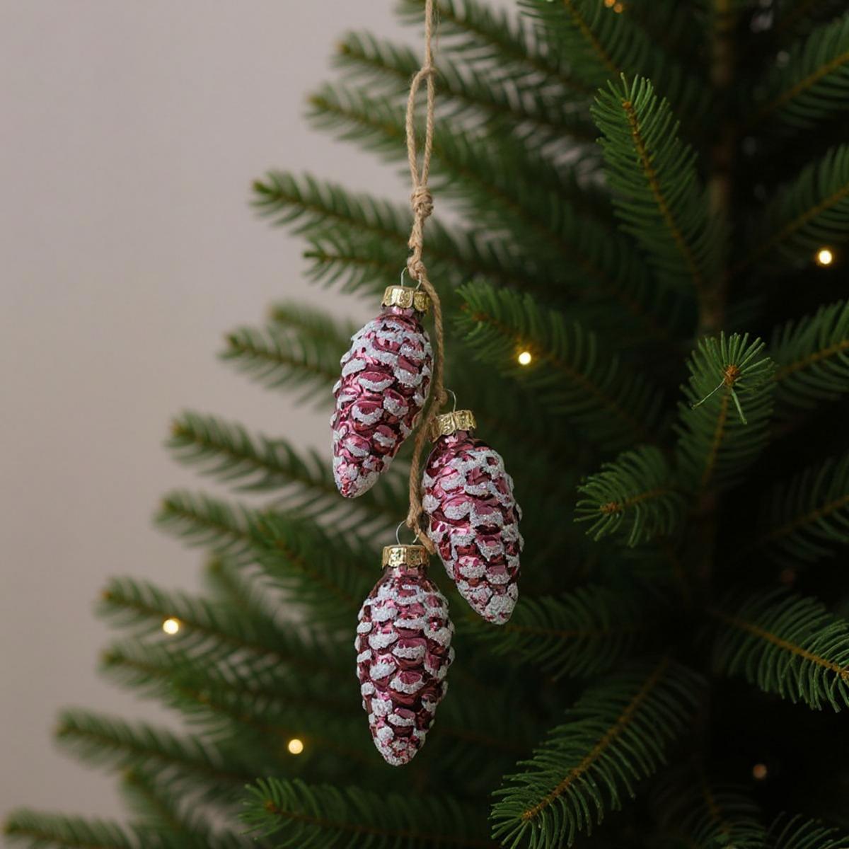 Trois décorations de pommes de pin sur un sapin de Noël