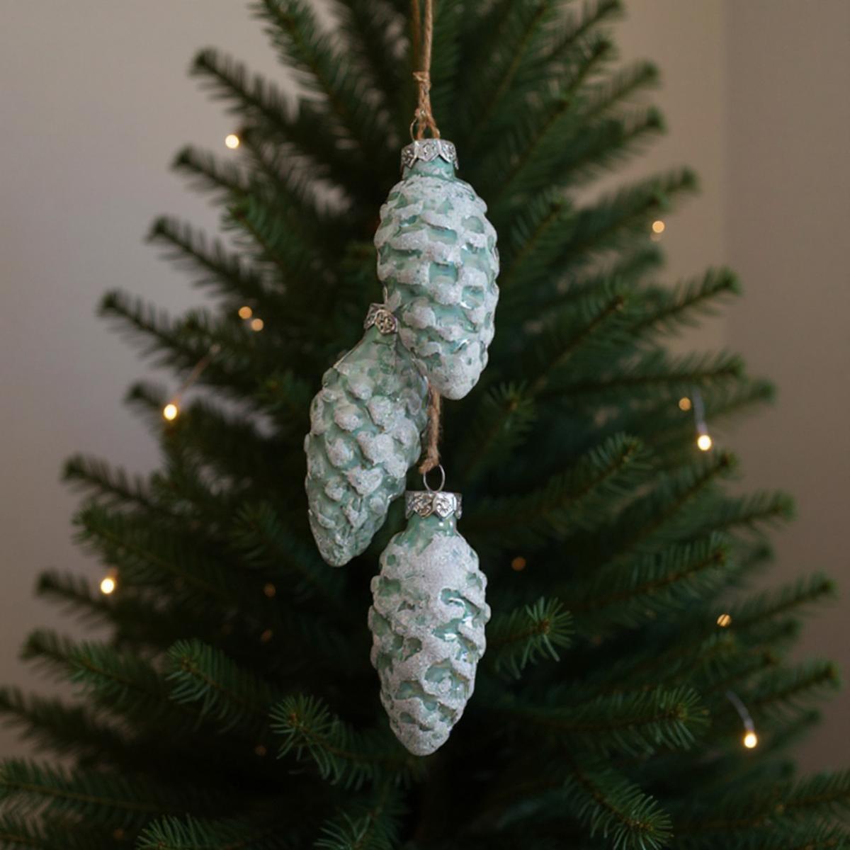 Palline di Natale a forma di pigna smerigliata appese all'albero di Natale