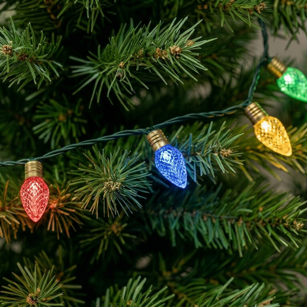 Guirlande lumineuse de Noël avec des ampoules rouges, bleues, jaunes et vertes sur un sapin