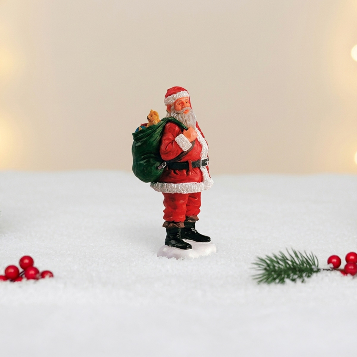 Figurine du Père Noël portant un sac de cadeaux dans la neige