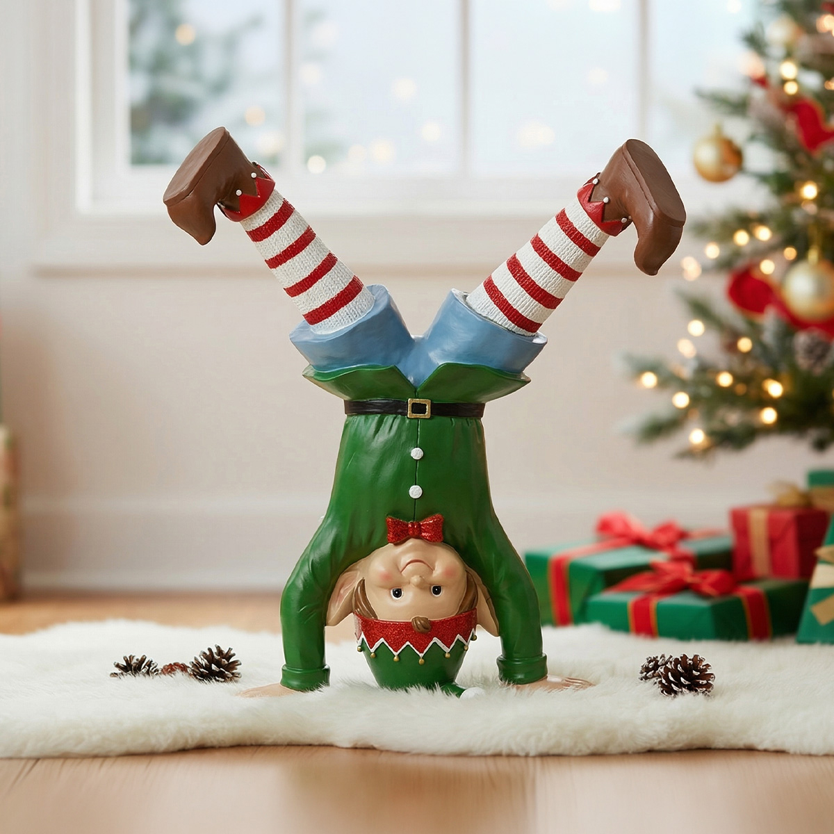 Figurine de lutin de Noël faisant le poirier sur un tapis blanc