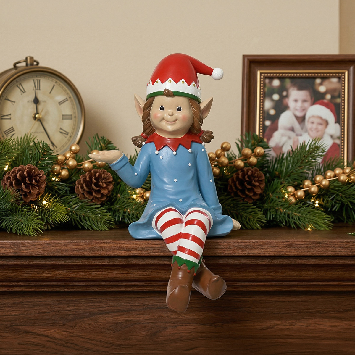 Figurine de lutin de Noël assise sur une cheminée décorée